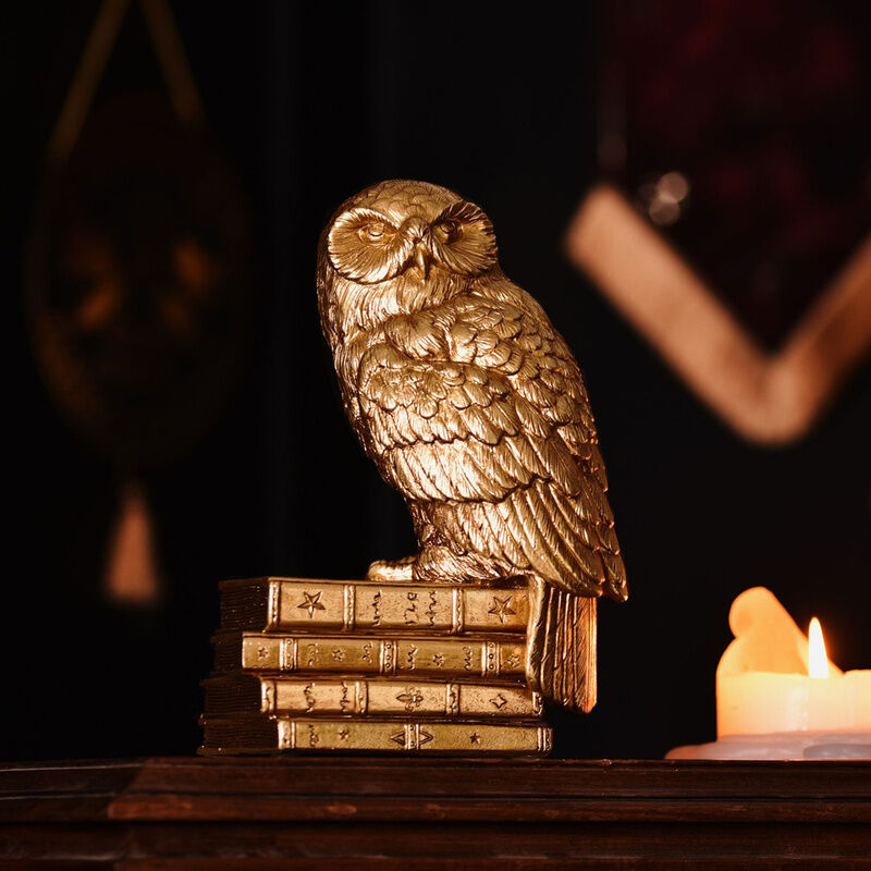 Figura dorada de Hedwig de Harry Potter sobre una pila de libros - 5