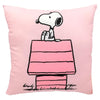 Cojín rosa de Snoopy sentado sobre su caseta