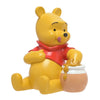 Hucha de resina de Winnie the Pooh junto a un tarro de miel