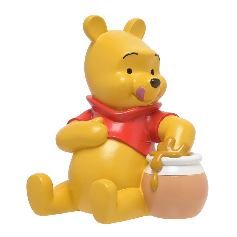 Hucha de resina de Winnie the Pooh junto a un tarro de miel