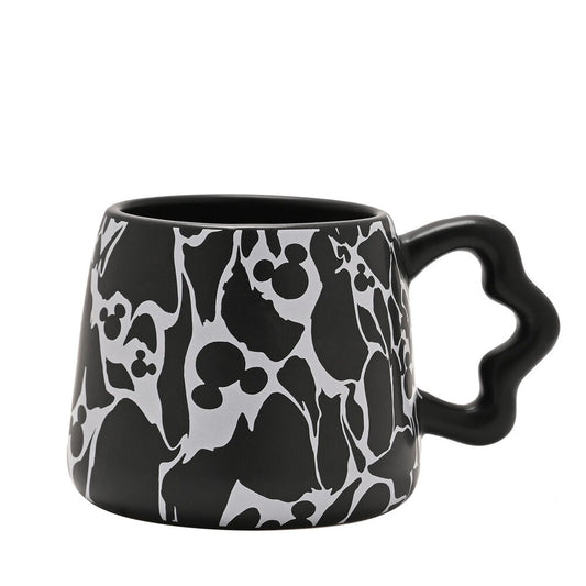 Taza negra de Mickey Disney con siluetas blancas y asa ondulada