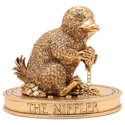 Figura dorada del Niffler de Harry Potter sobre base ovalada